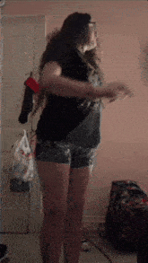 a woman in shorts and a black shirt is standing in front of a door with a bag that says ' canadian tire '