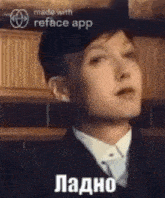 a young man in a suit and tie is making a funny face with a reface app .