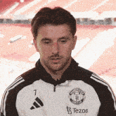 a man wearing a manchester united jacket with the number 7 on the front