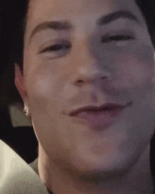 a close up of a man 's face with a slight smile on his face