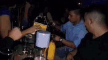a blurry picture of a group of people at a bar with a green heineken bottle in the foreground