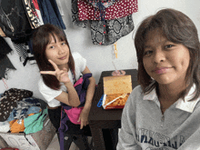 two girls sitting at a table with a bag of mcdonald 's chicken nuggets