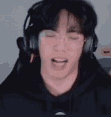 a close up of a man wearing headphones and making a funny face .