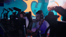 a man wearing headphones sits in front of a computer screen with the letter h in the background