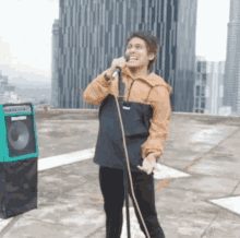 a man singing into a microphone on a roof
