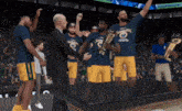 a group of basketball players holding a trophy with the word champions on it