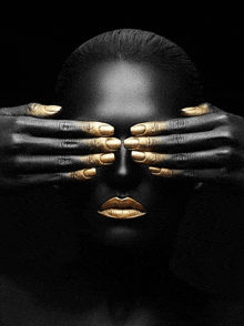 a woman with black and gold paint on her face covers her eyes with her hands