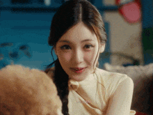 a close up of a woman holding a poodle with korean writing on her face
