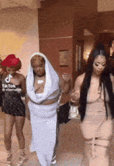 a group of women are walking down a hallway with a tiktok watermark on the bottom left