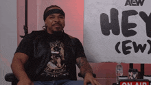 a man sitting in front of a sign that says hey crew