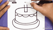 a person is drawing a cake with a marker