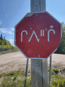 a stop sign on a wooden post with the letters g and i on it
