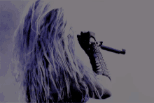 a woman singing into a microphone with spikes on her gloves