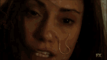 a close up of a woman 's eye with blood coming out of it .