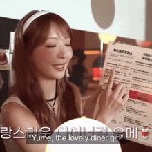 a woman is holding a menu in front of a sign that says burgers