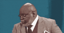 a man in a suit and tie with glasses and a pocket square