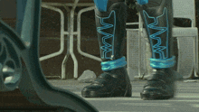 a person wearing a pair of black boots with a blue stripe on the bottom