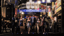 a group of people are walking in front of a building that says syofuku-cho