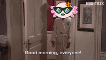 a woman in a bathrobe is standing in a doorway and says good morning everyone