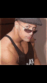 the rock is wearing sunglasses and a hat .