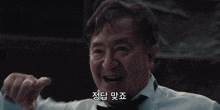 a man wearing a tuxedo and bow tie is smiling in a dark room