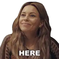 a woman is smiling and says here in black letters