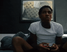 a man in a white shirt is holding a video game controller