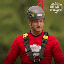 a man wearing a helmet and a red shirt that says canada 's ultimate challenge on it
