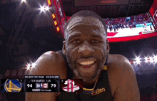 a basketball player is smiling in front of a scoreboard that says rakuten on it