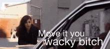 a woman standing next to a car with the words move it you wacky bitch above her
