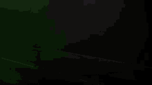 a green and purple car is driving down a dark street .