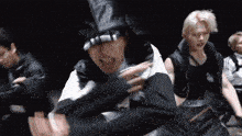 a group of young men are dancing in a dark room in a video .