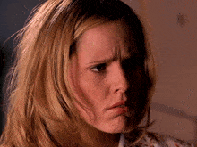 a close up of a woman 's face with a serious look on her face