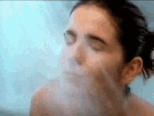 a woman is taking a shower with her eyes closed and steam coming out of her face