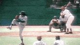 a baseball player throws a pitch while a catcher watches