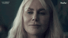 a close up of a woman 's face with the words nine perfect strangers below her