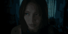 a close up of a woman 's face in the dark looking at the camera .