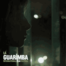 a poster for la guarimba international film festival shows a woman in a dark room