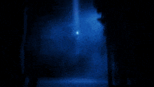 a blue smoke coming out of a hole in the dark .