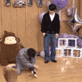 a man kneeling down in front of a stuffed monkey