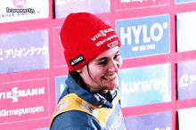 a person wearing a red beanie with the word hylo on it