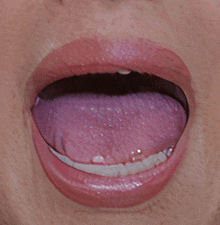 a close up of a person 's mouth with their tongue sticking out