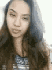 a woman with long hair is making a funny face .