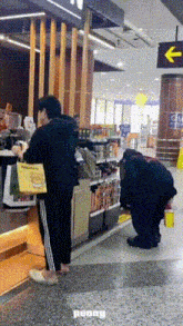 a man kneeling down in front of a store with the word penny on the ground