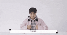 a young man in a pink jacket is sitting at a table with a quote .