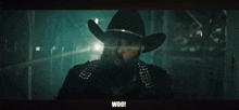 a person is standing in a dark room with the word woo written on the bottom