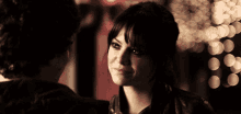 a man and a woman are looking at each other in a dark room