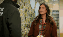a man wearing a texas ranger jacket stands next to a woman holding flowers