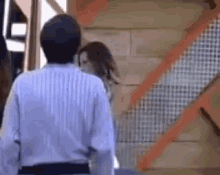 a man and woman are standing next to each other in front of a building .