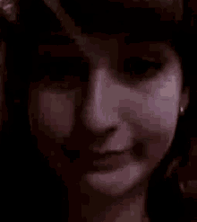 a close up of a woman 's face in a dark room